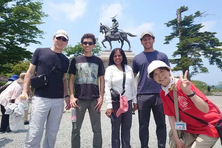 A licensed guide and travellers at a temple gate on a private Sendai and Matsushima Bay tour
