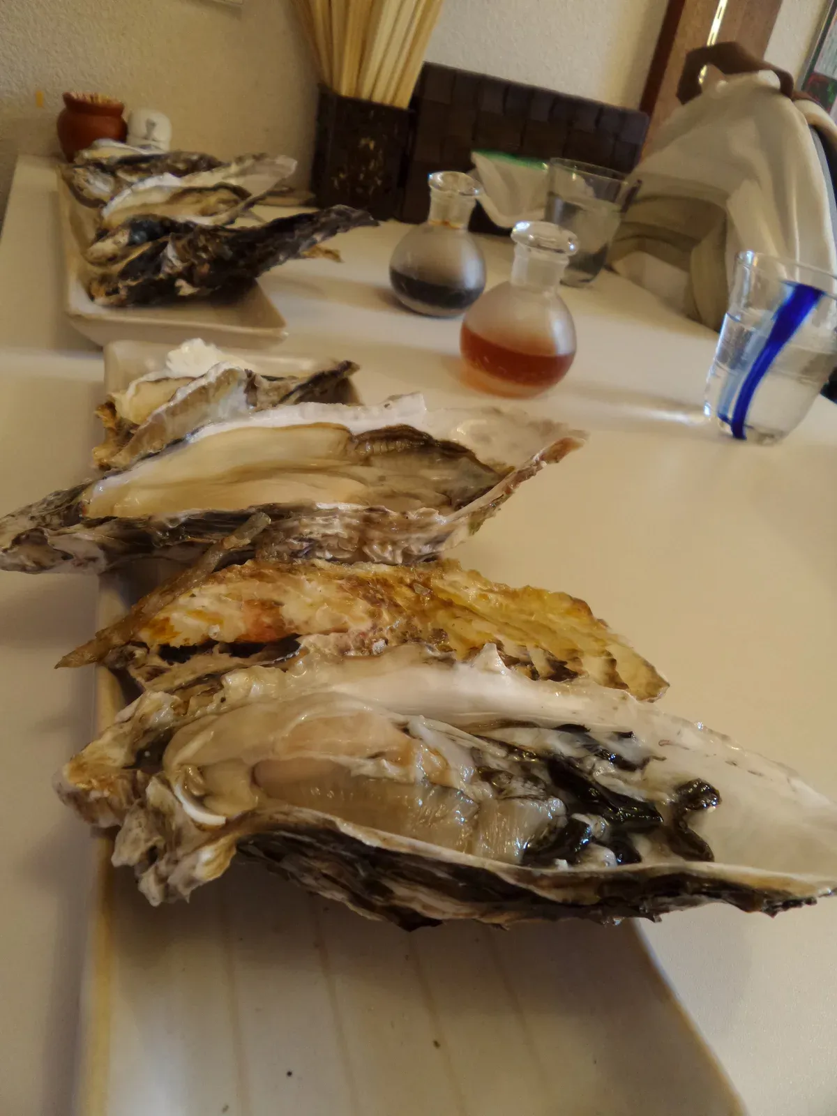 Raw oysters in their shells on a tray with soy sauce beside them